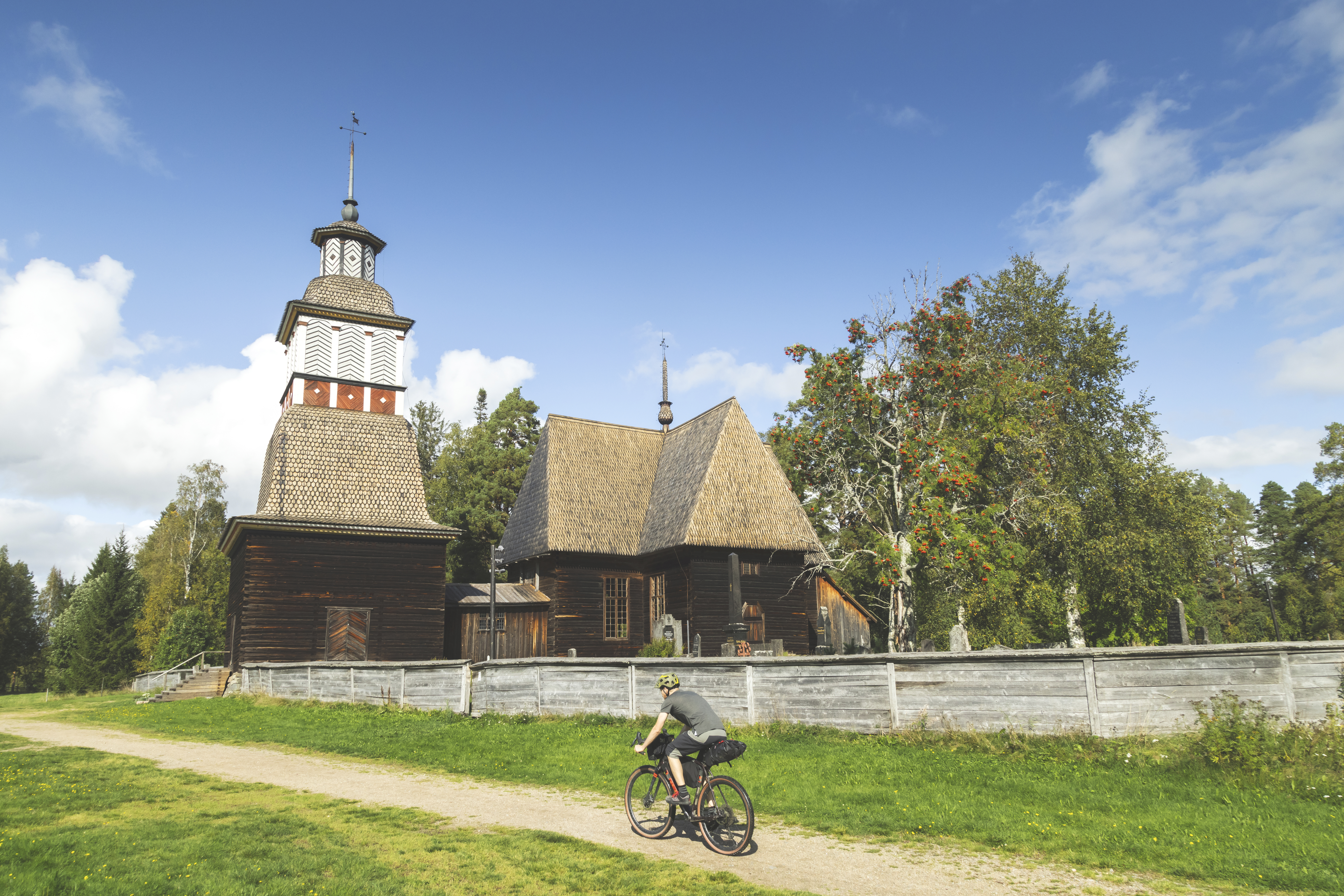 Cyclist riding past an old church