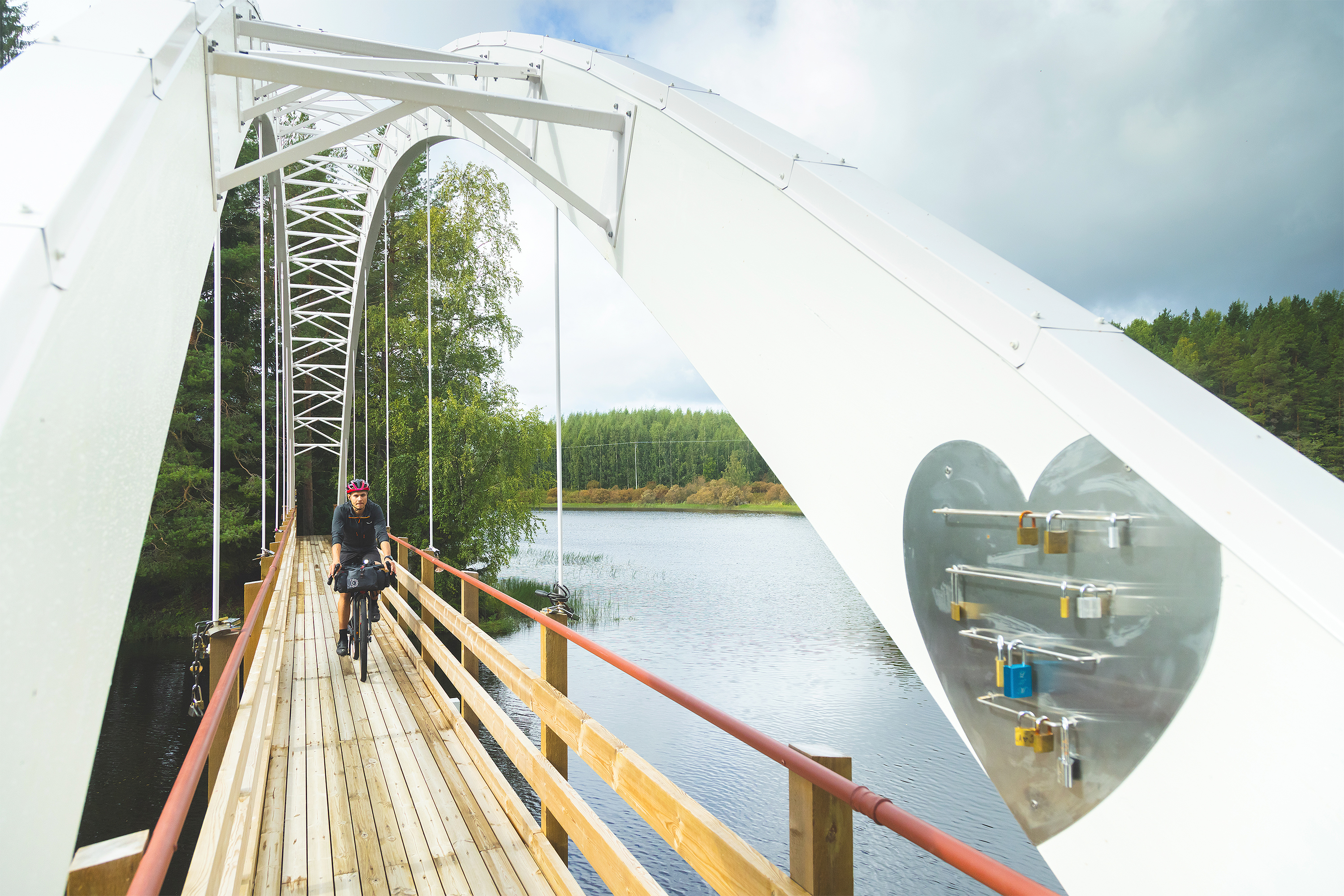 Cyclist crossing a river on a bridge