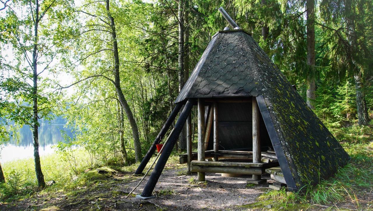 Suuri kotalaavu järven rannalla. Taustalla näkyy metsää.