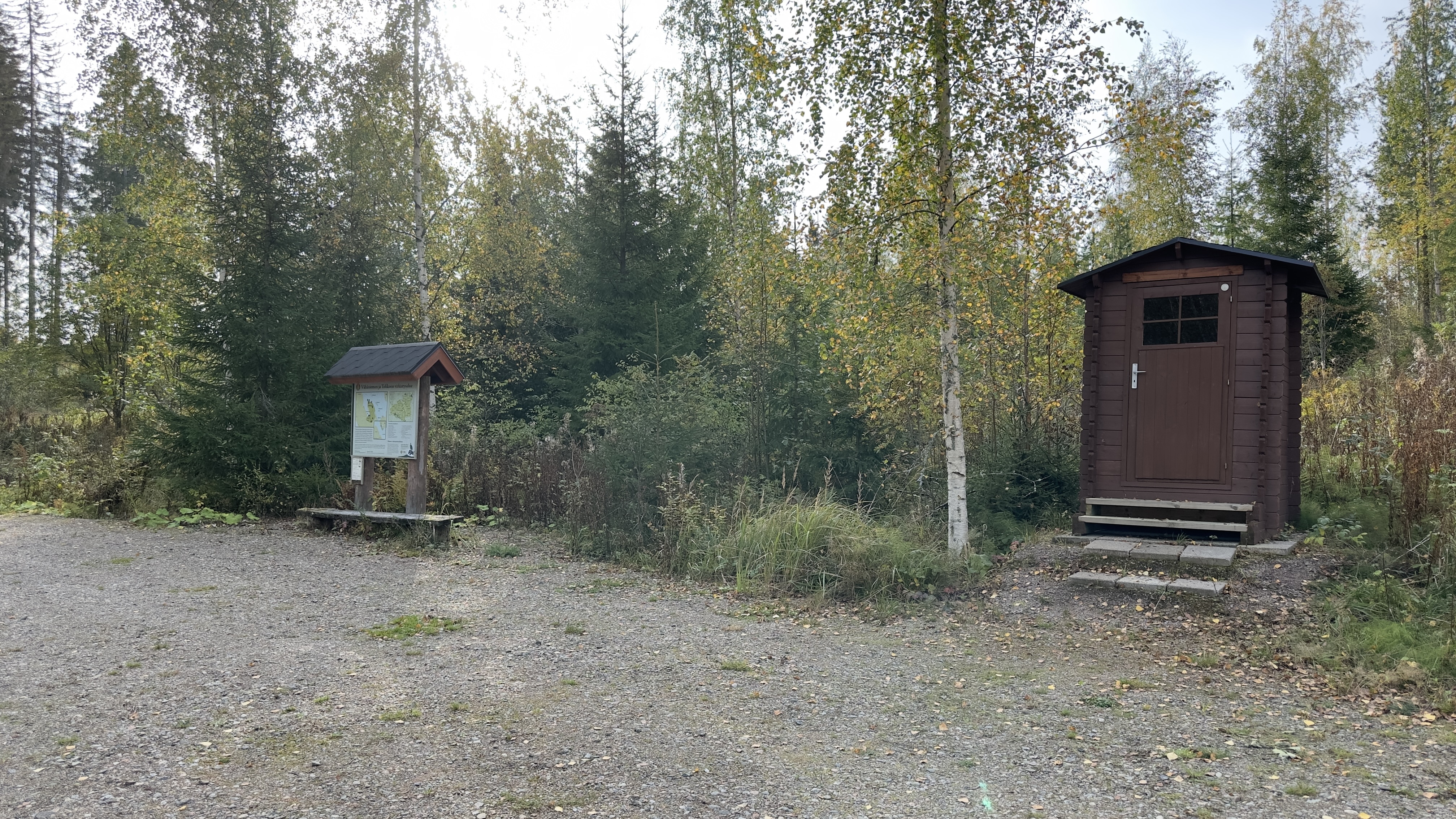 Puinen kuivakäymälä, jonka vieressä on infotaulu.