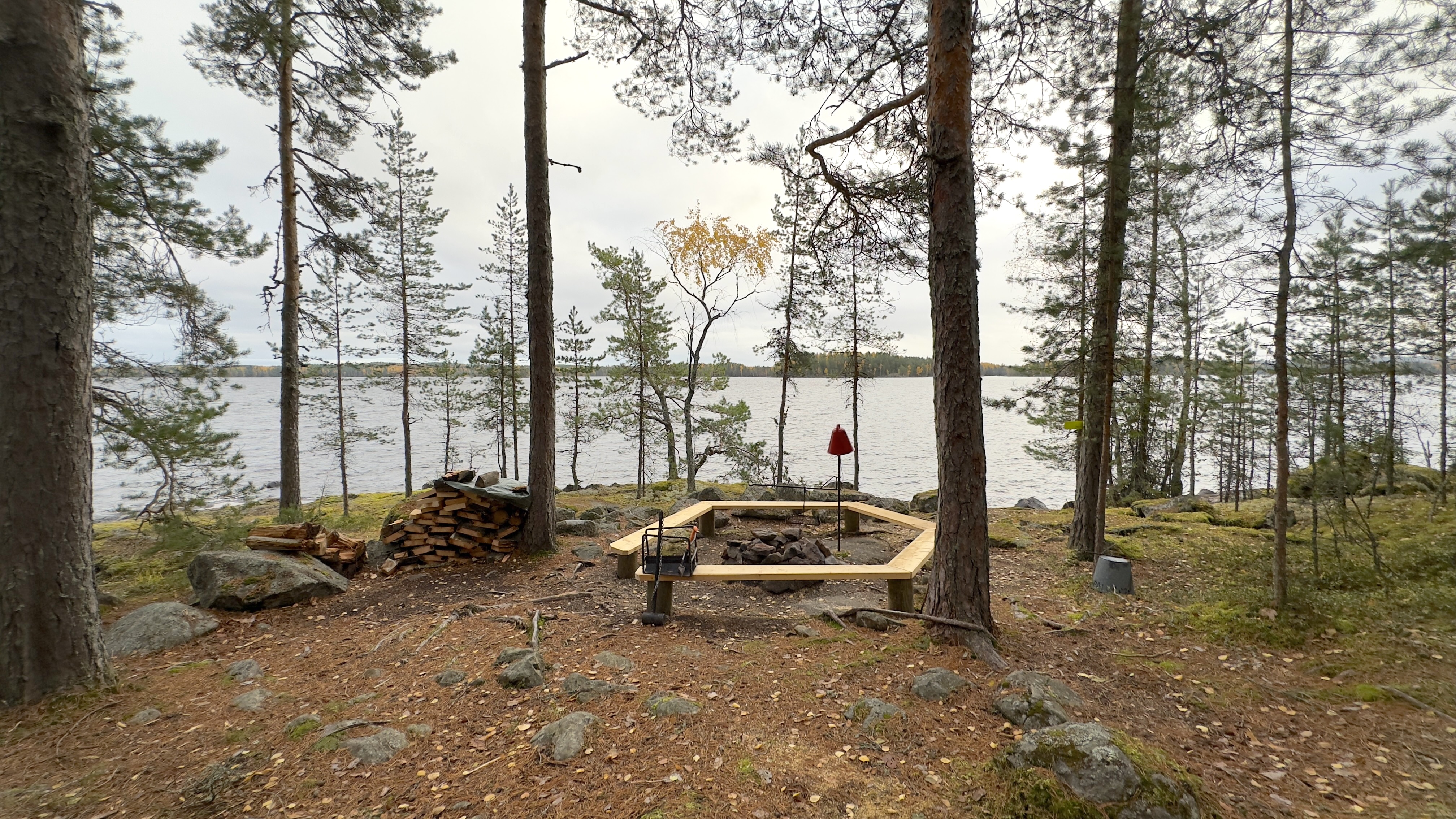 Wooden campfire site in the forest by the lake.
