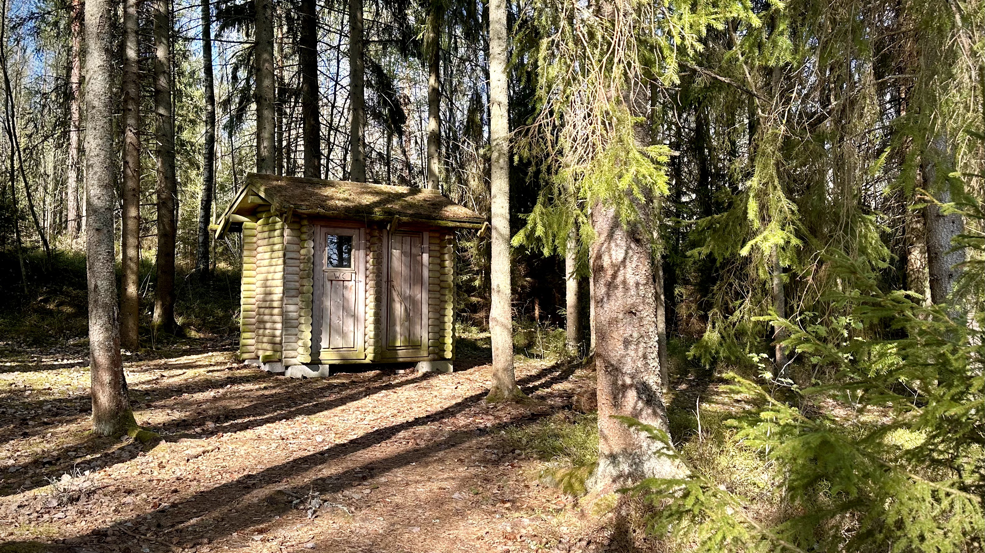 Log building with two doors in the forest.