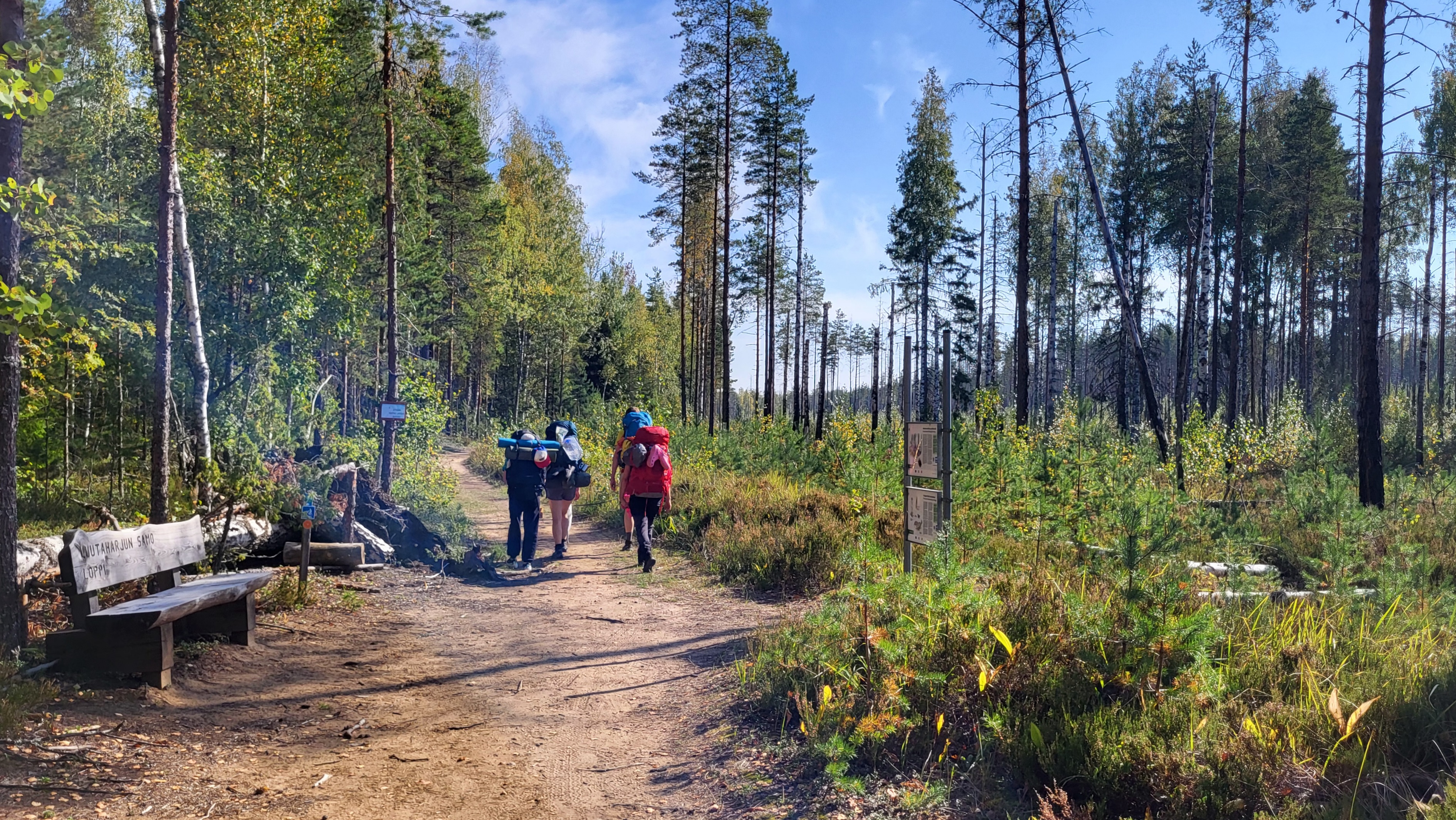 Vaeltajat kävelevät hiekkapolulla.