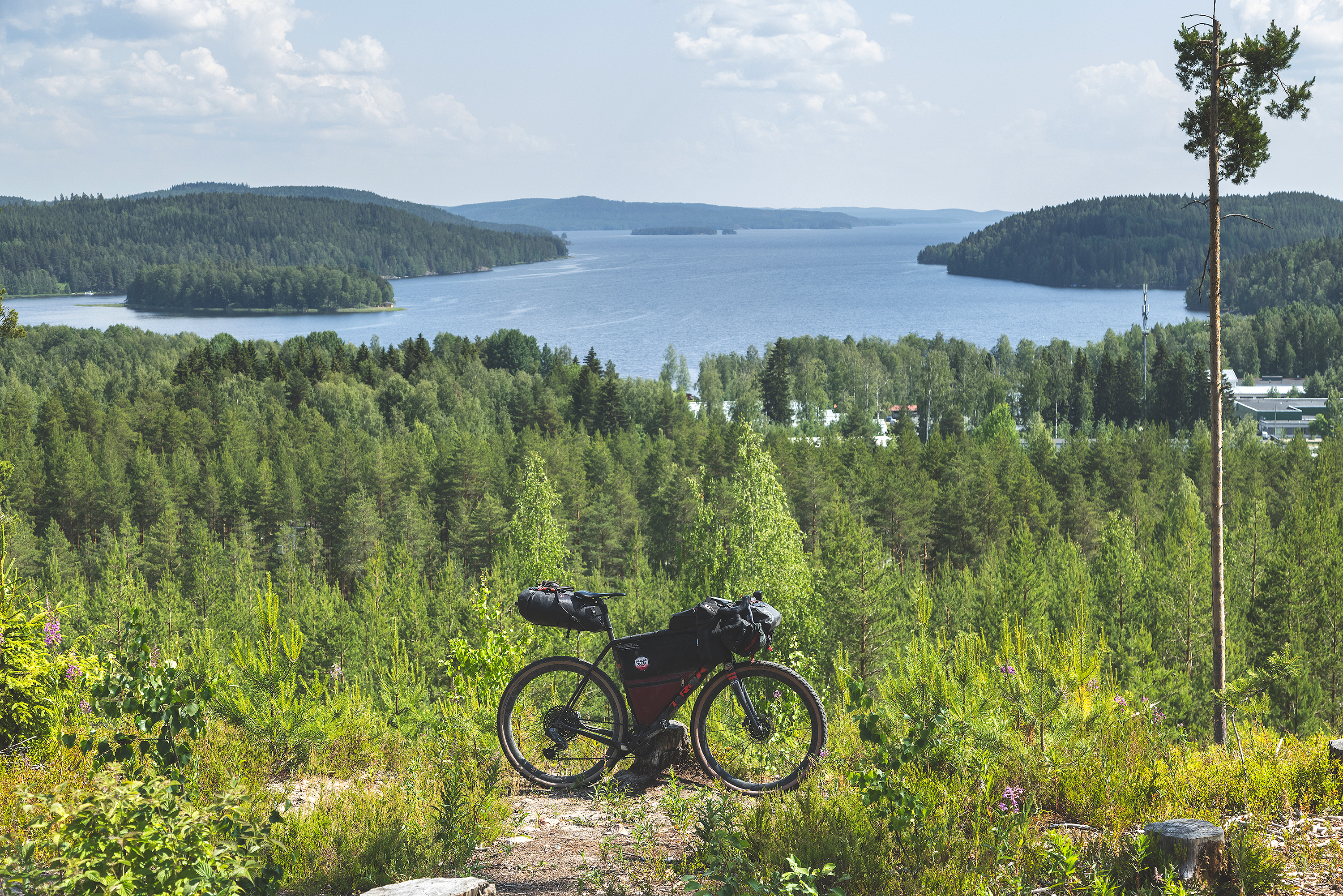 Gravel bike on a hill with lake scenery behind it.