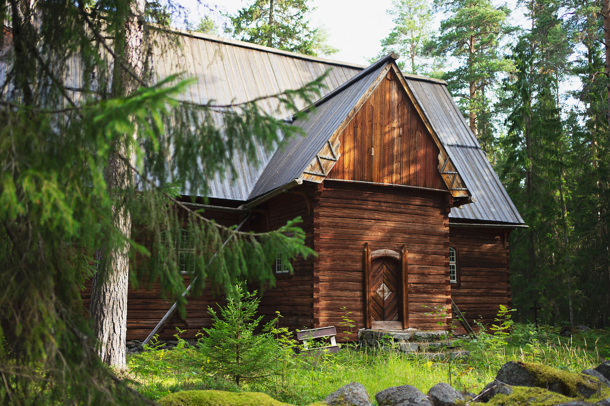 Puinen erämaakirkko keskellä metsää.