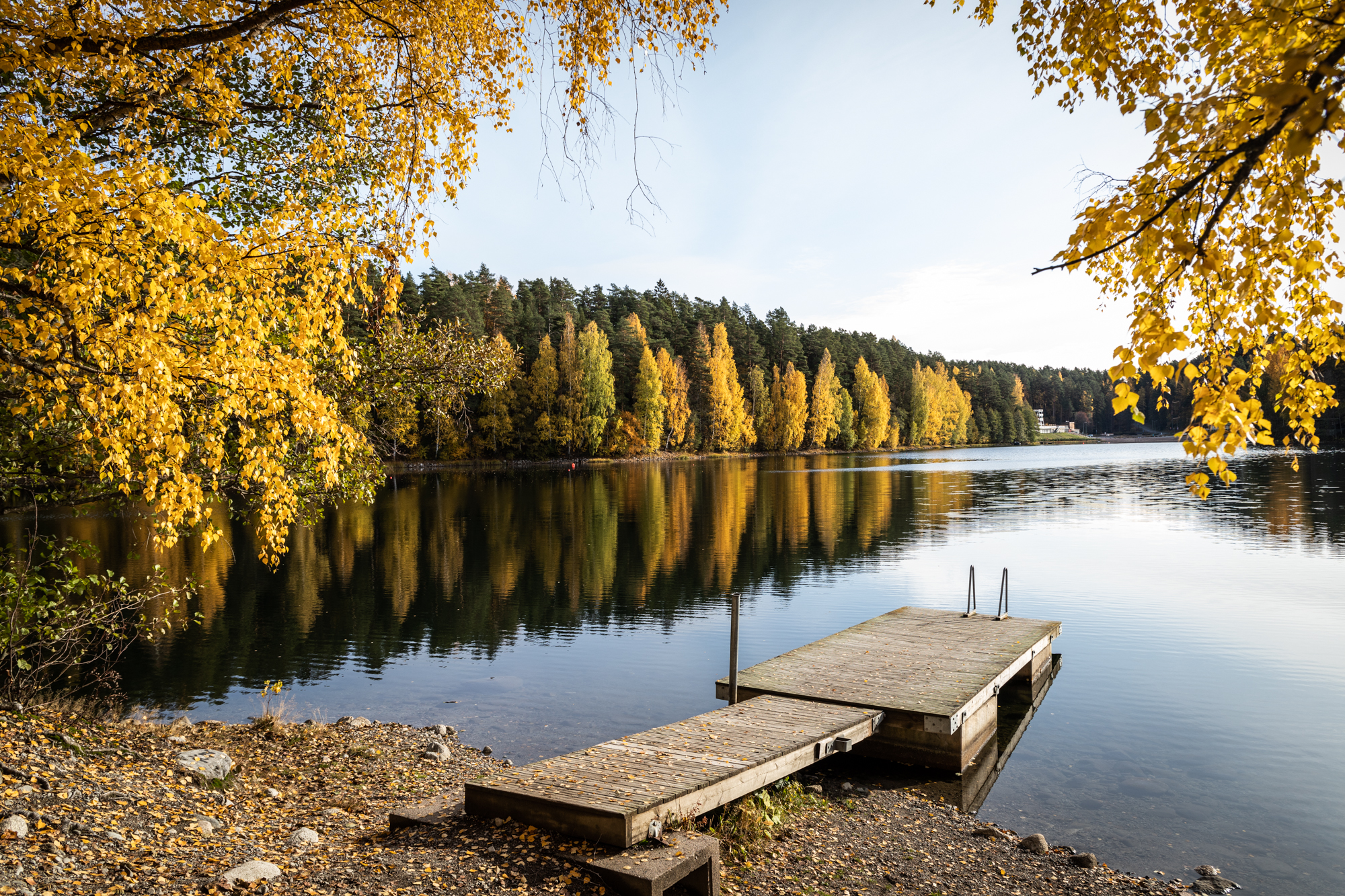 Edessä  puinen laituri ja takana järvimaisema ruskanväreissä